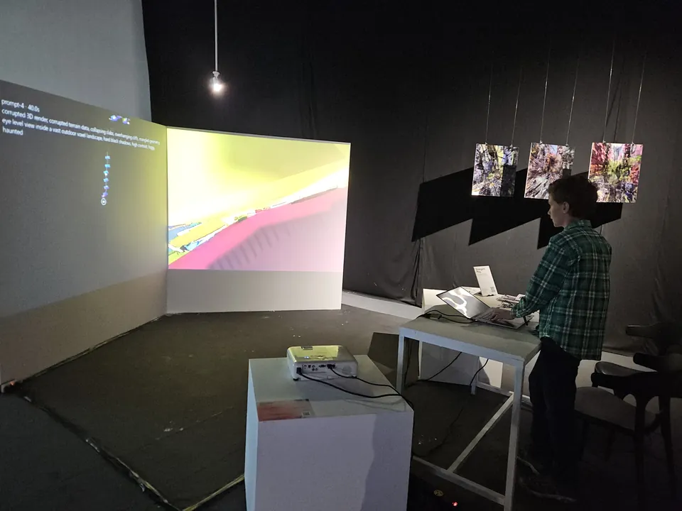 A visitor standing at the controls in front of a large projected game landscape.