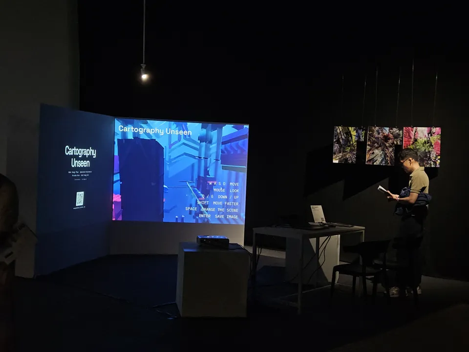 A visitor looking toward the game projection and a row of suspended prints.